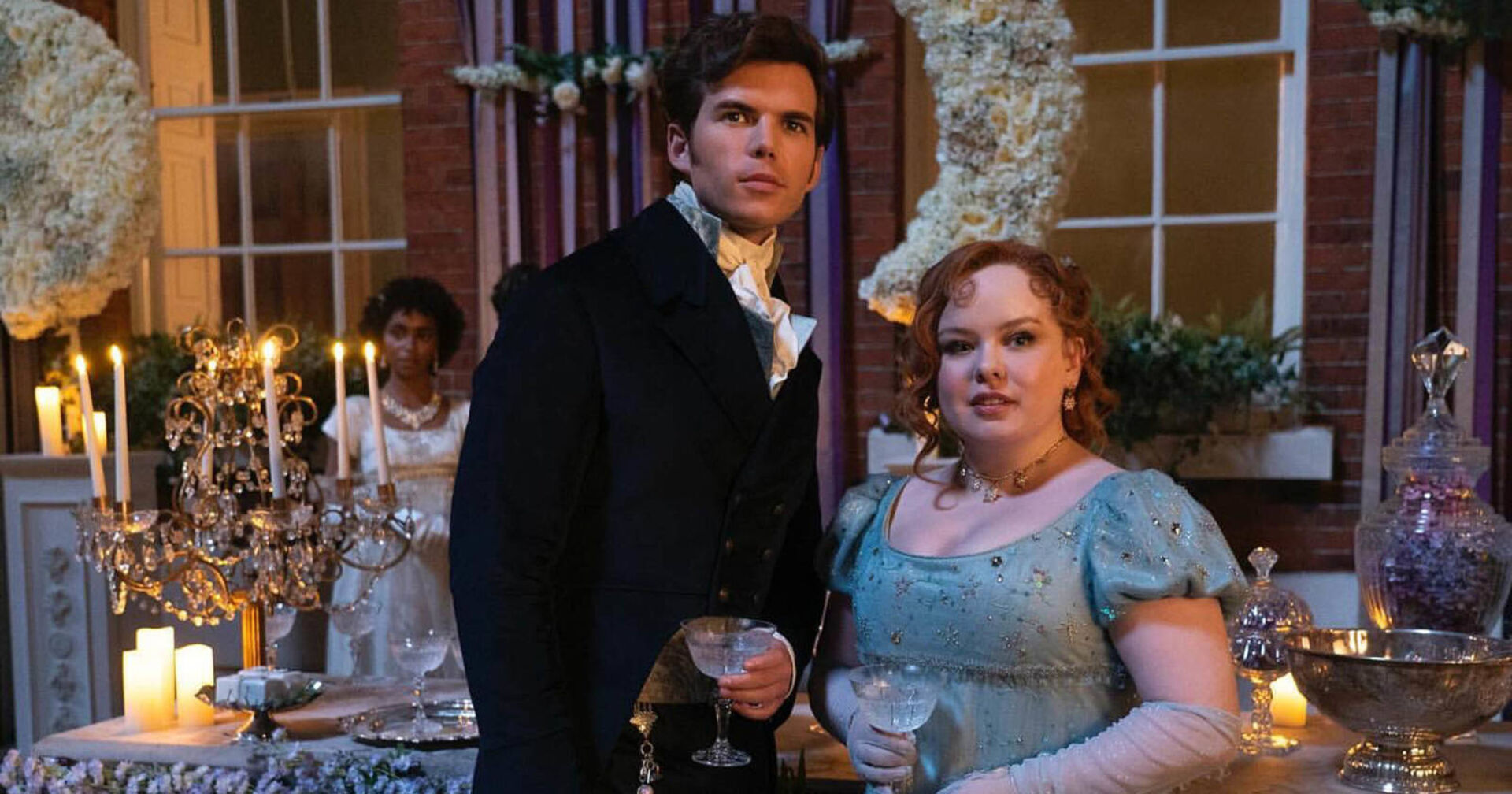 Ein Mann und eine Frau in höfischer Kleidung stehen in einem Ballsaal