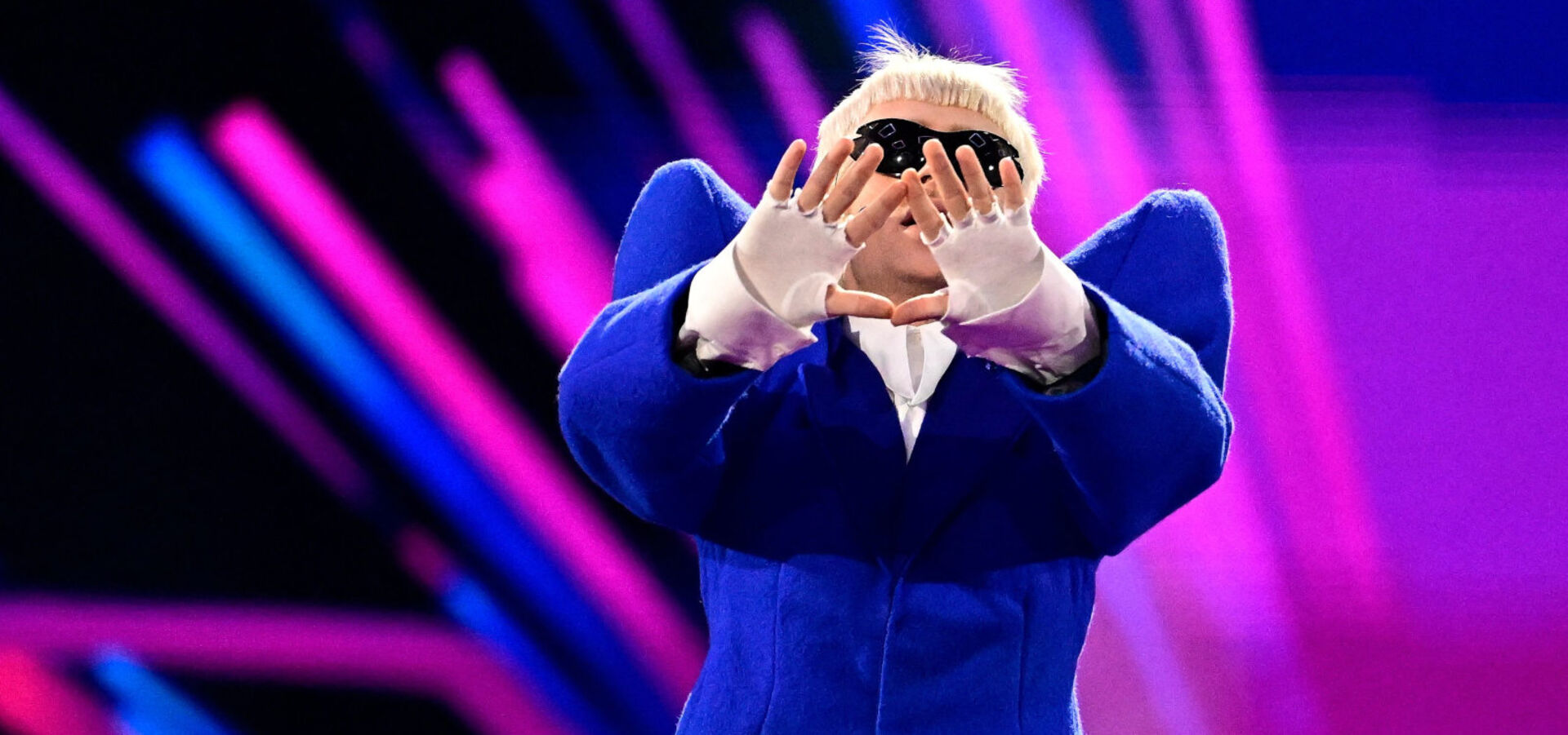 Mann im blauen Anzug hält sich die Hände vors Gesicht