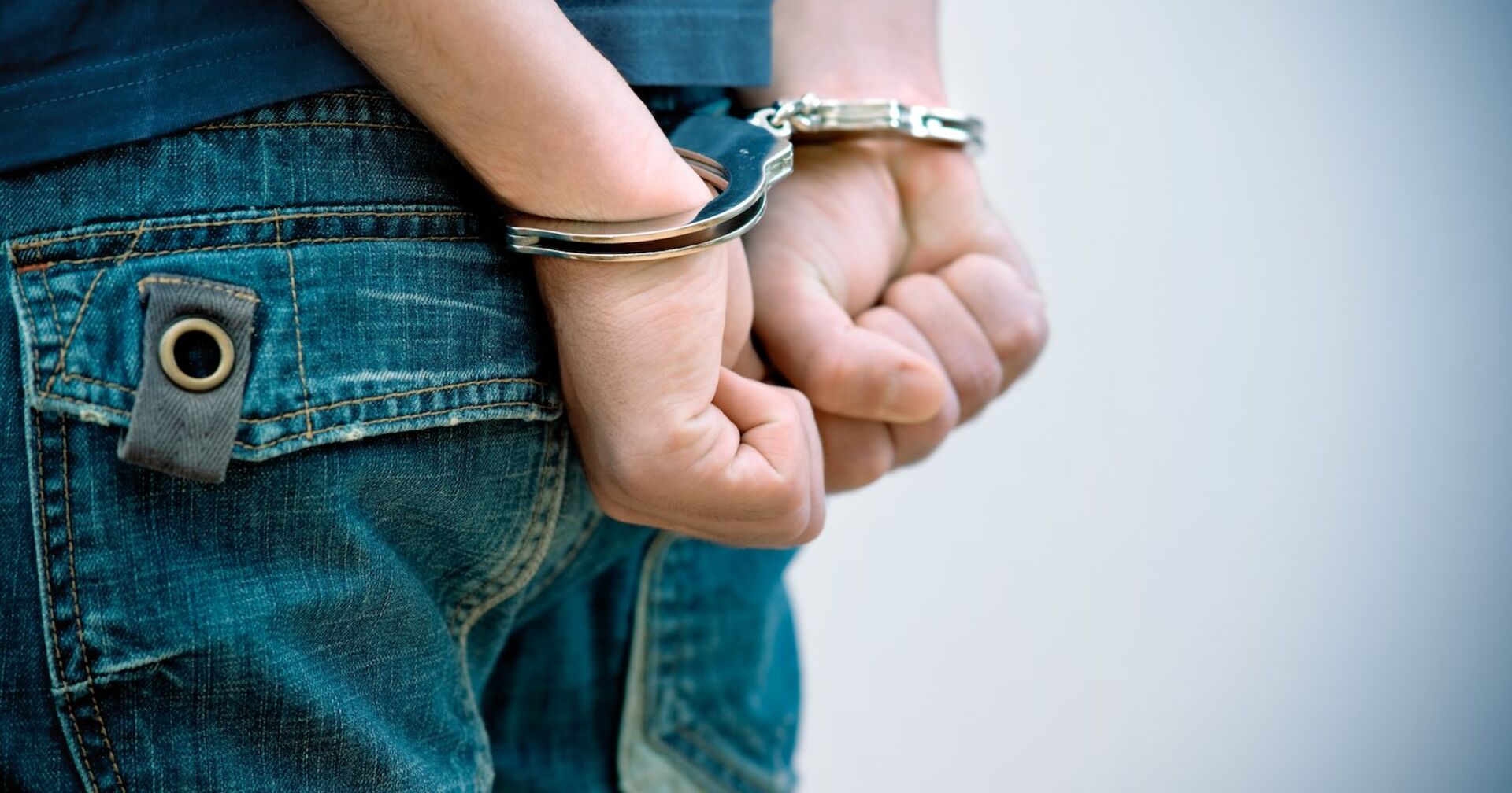 Ein Jugendlicher in Handschellen.