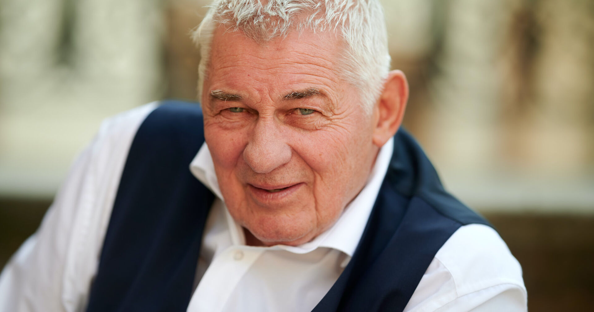 Heinz Hoenig in einem weißen Hemd mit einer dunklen Weste.