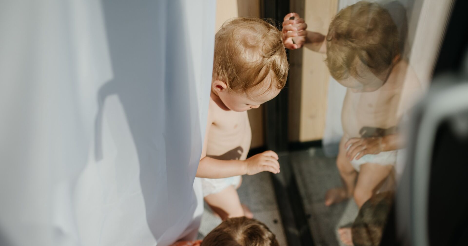 Zwei Kinder spielen an einer Terrassentür.