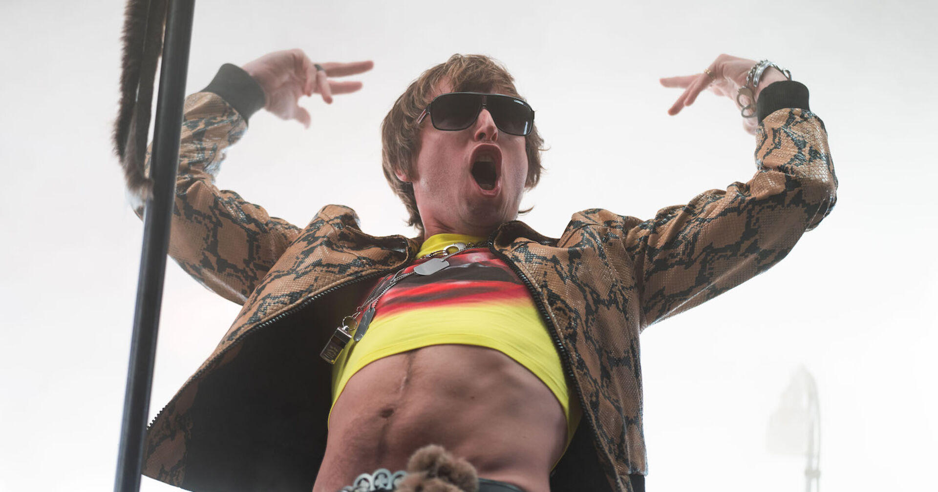 Maurice von Bilderbuch mit einem bauchfreien Top und einer Lederjacke.