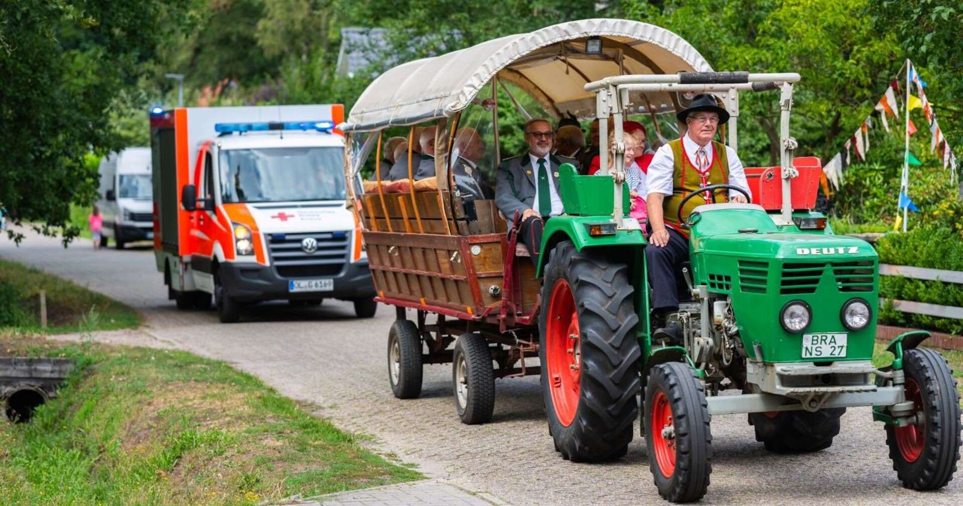 Traktorausfahrt mit Anhänger, dahinter ein Rettungswagen.