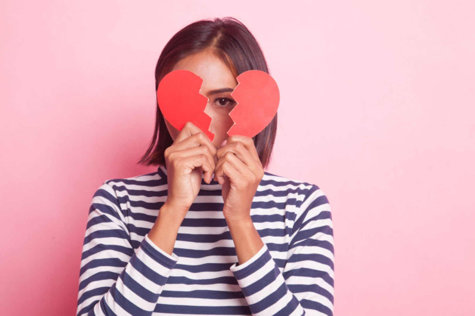 Frau mit einem gebrochenen Herzen in der Hand
