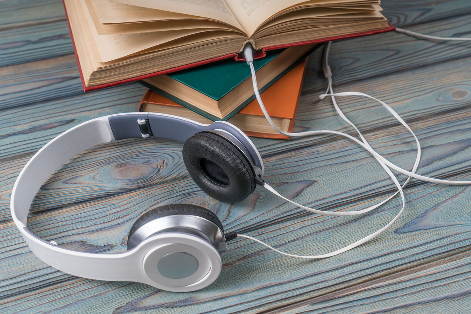 Bücherstapel mit Kopfhörern | Credit: iStock.com/Gerasimov174