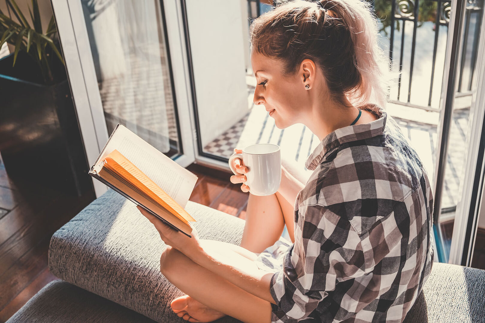 Frau liest am Balkon | Credit: iStock.com/Vadmary