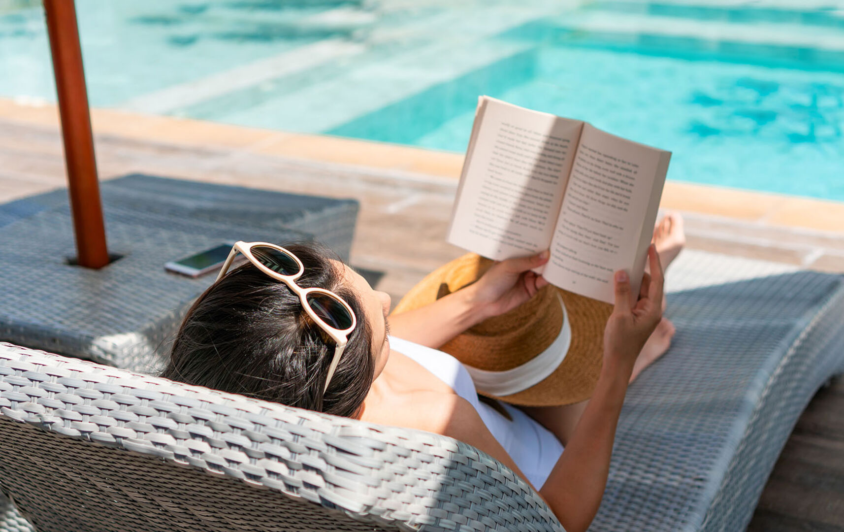 Frau liest im Pool | Credit: iStock.com/Pattarisara Suvichanarakul