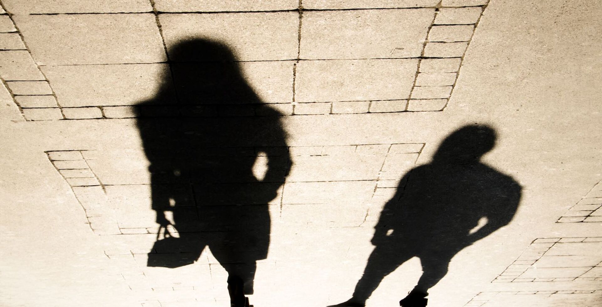 Schatten eines Mannes, der einer Frau nachstellt.