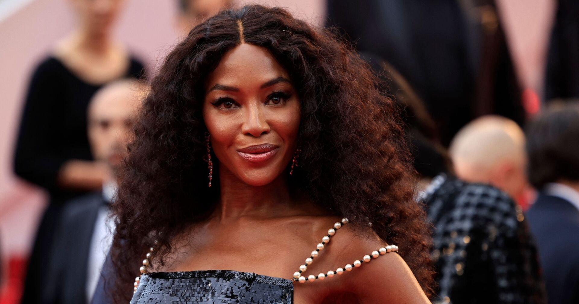 Naomi Campbell mit voluminösen gelockten Haaren auf dem Red Carpet.