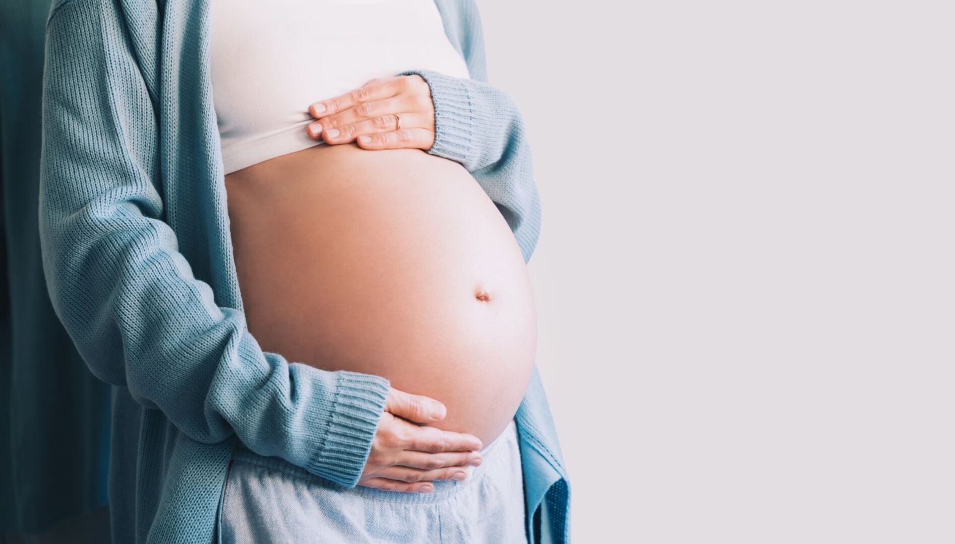 Schwangere Frau, die ihren Bauch hält
