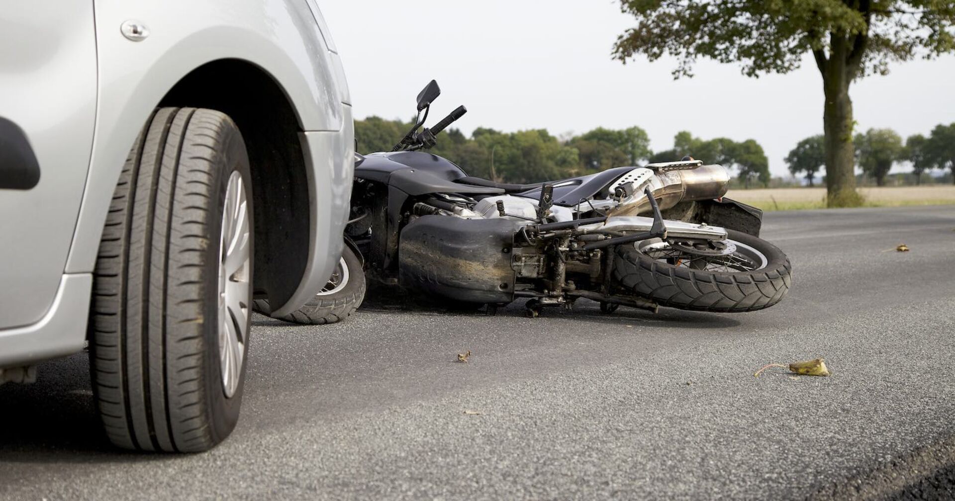 Unfall: Ein Motorrad liegt vor einem Pkw.