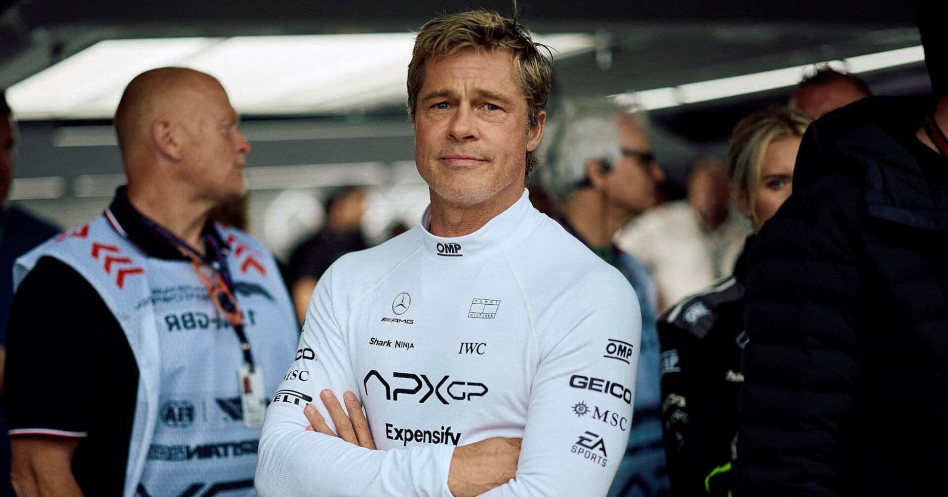 Mann in weißem Rennanzug mit verschränkten Armen blickt in die Kamera