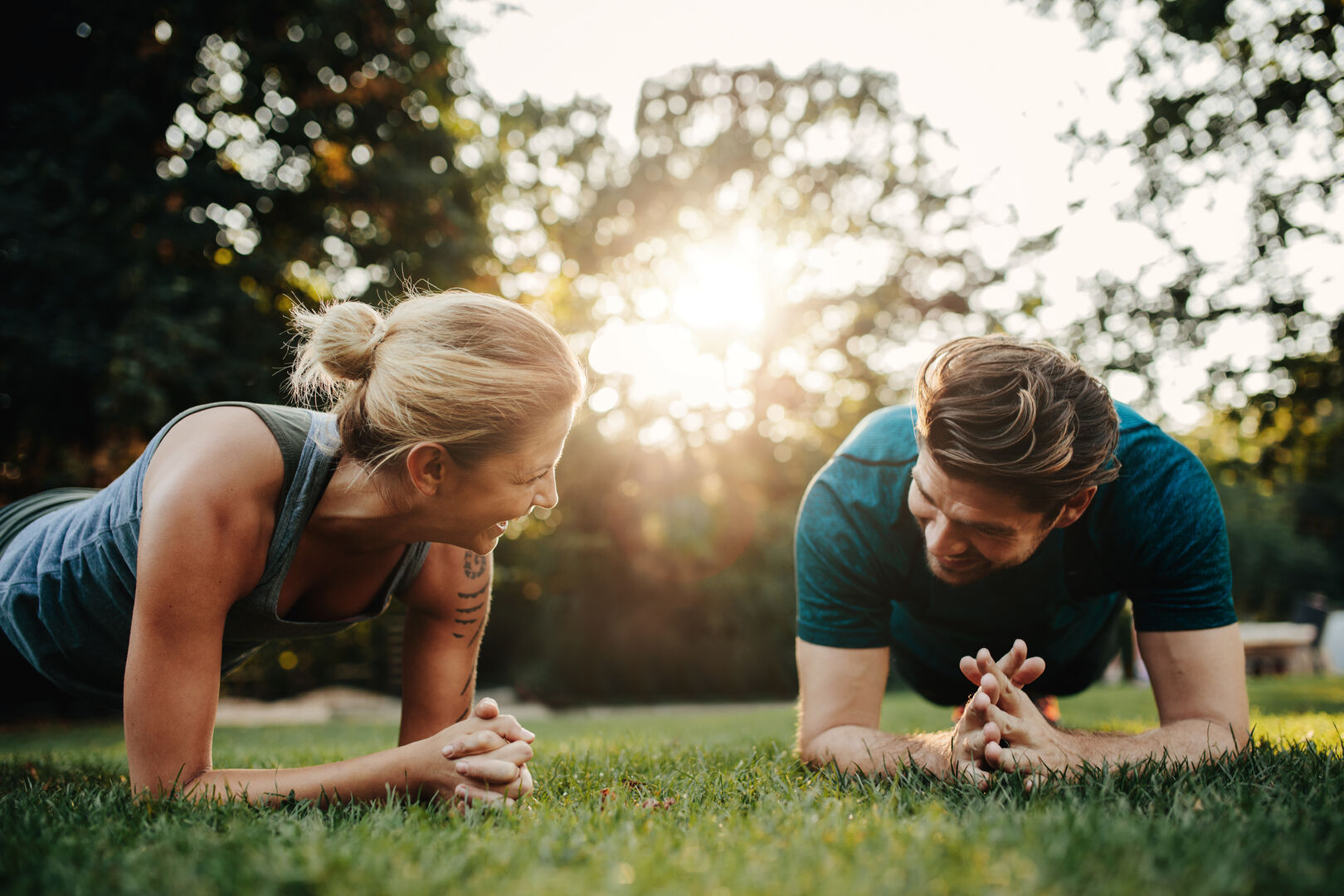 Eine Frau und ein Mann beim Sport im Park, sie führen eine Plank-Übung aus