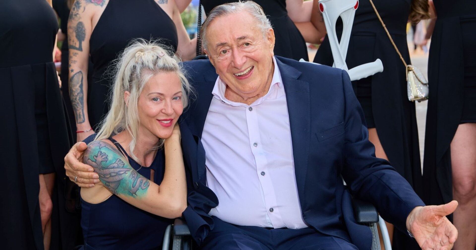 Richard Lugner im Rohlstuhl mit Simone.