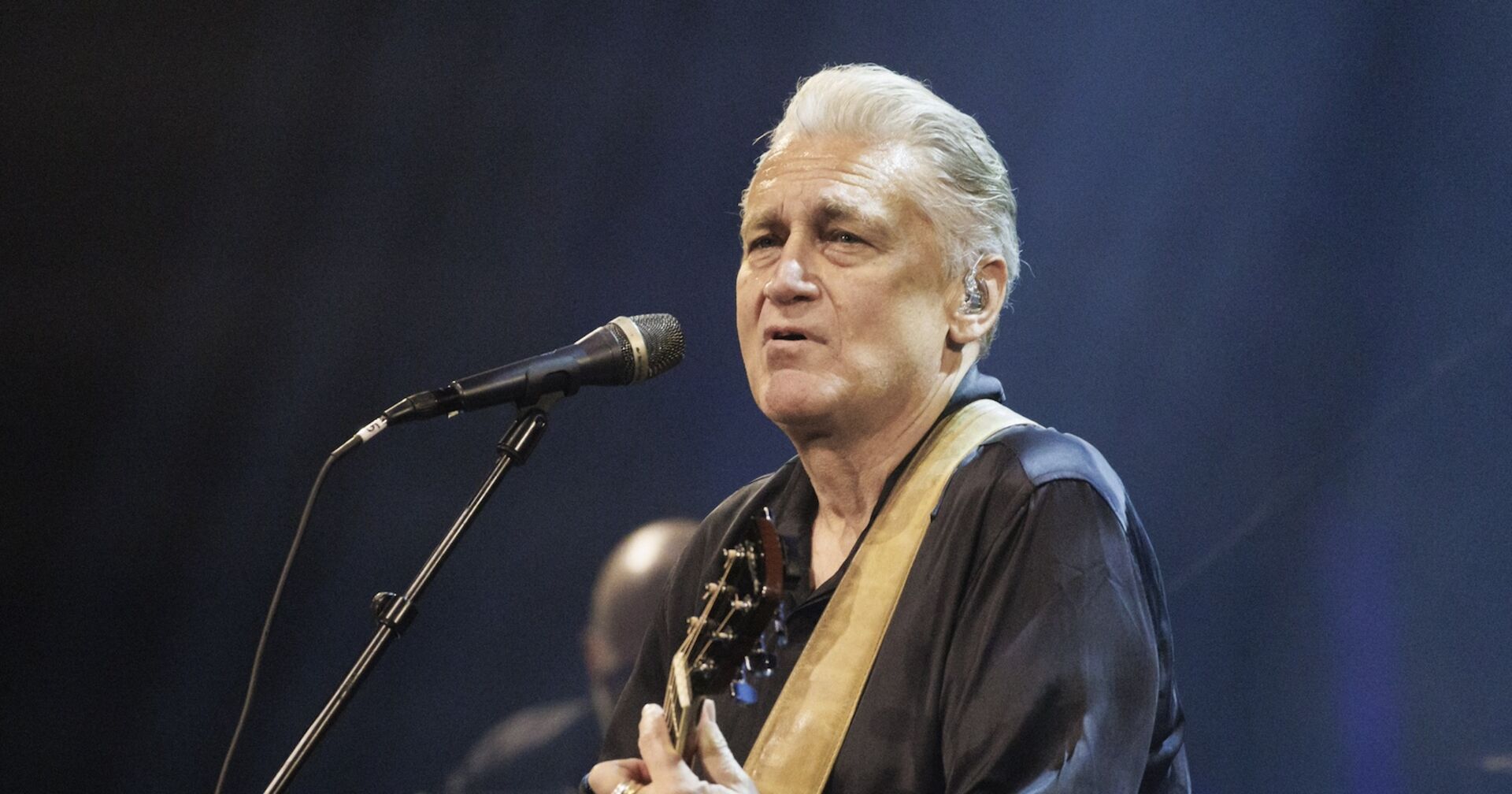 Rainhard Fendrich mit Guitarre singend auf der Bühne