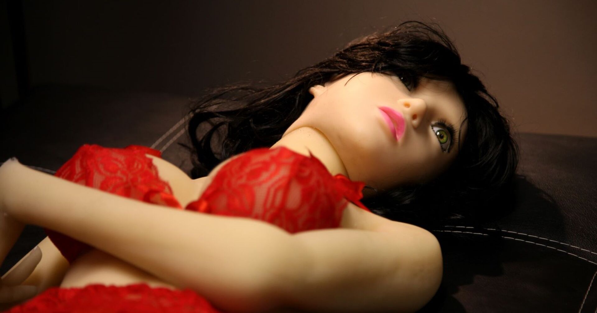 Eine brünette Sexpuppe mit roter Unterwäsche.