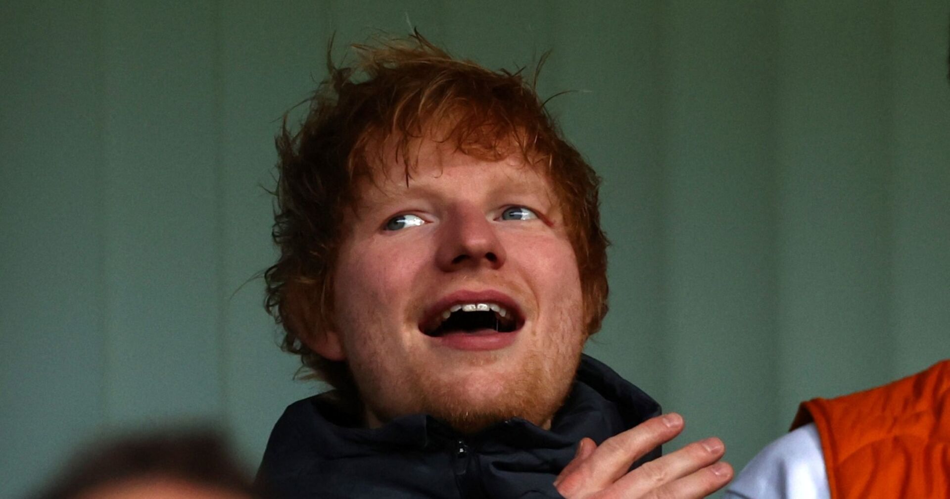 Ed Sheeran steht lächelnd auf der Bühne des Vereins Ipswich Town