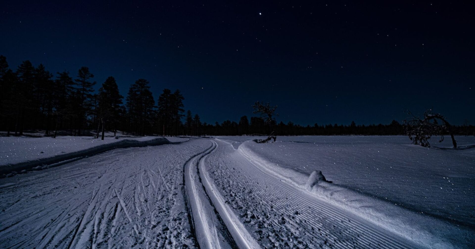 Eine Langlaufloipe in der Nacht.
