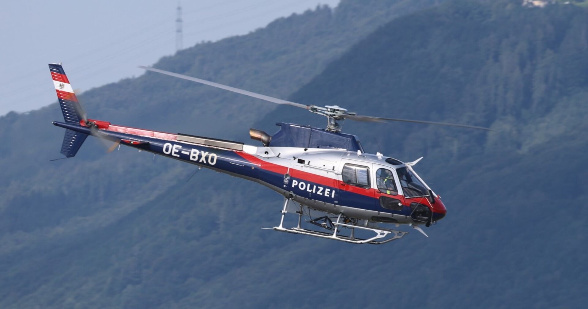 Hubschrauber der Polizei fliegt in den Bergen