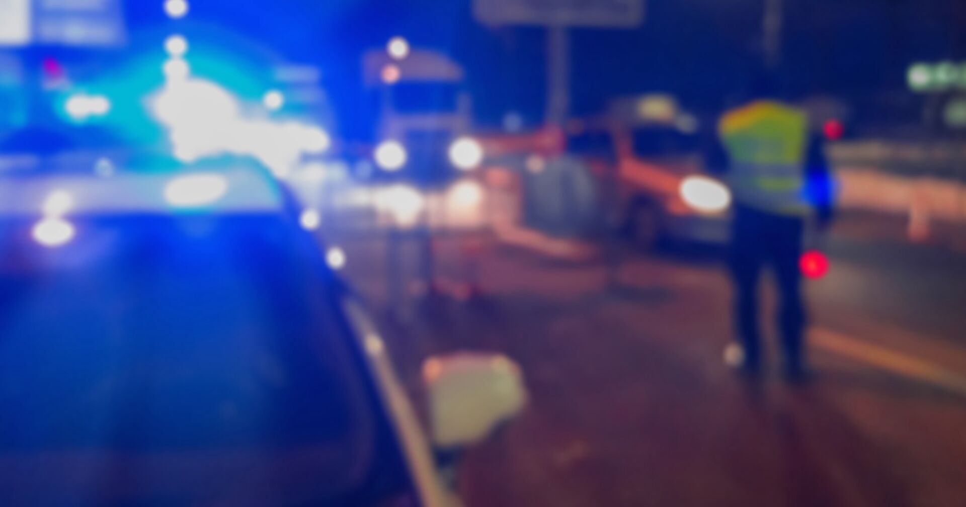 Nächtliche Polizeikontrolle mit Blaulicht.