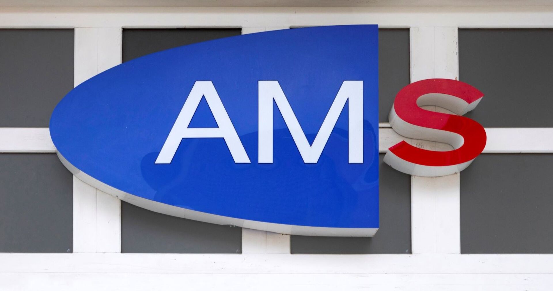 Logo des AMS an der Außenseite eines Gebäudes