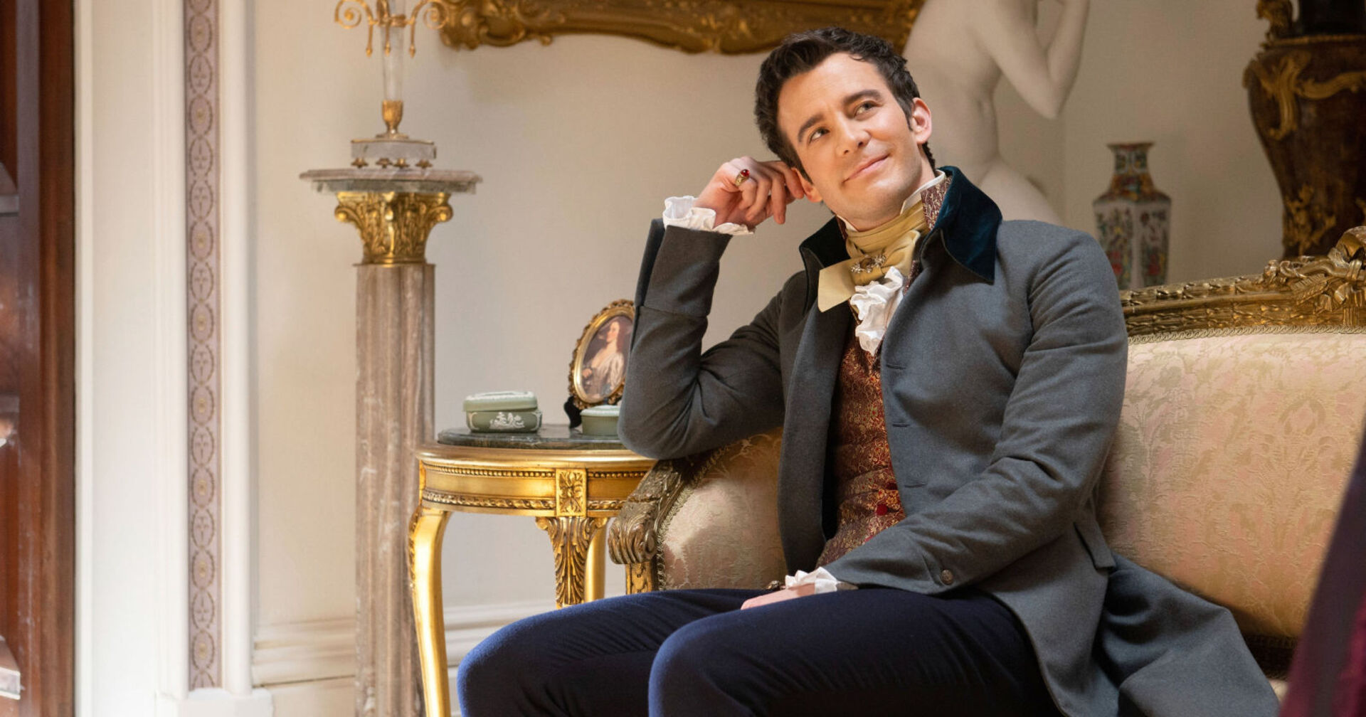 Ein Mann im Anzug sitzt auf einem Sofa