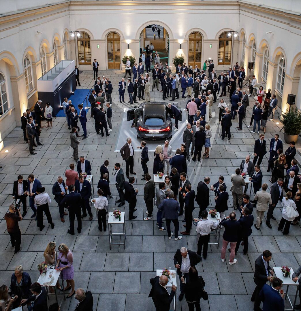 Menschengruppen und ein Auto im Innenhof des Palais Niederösterreich