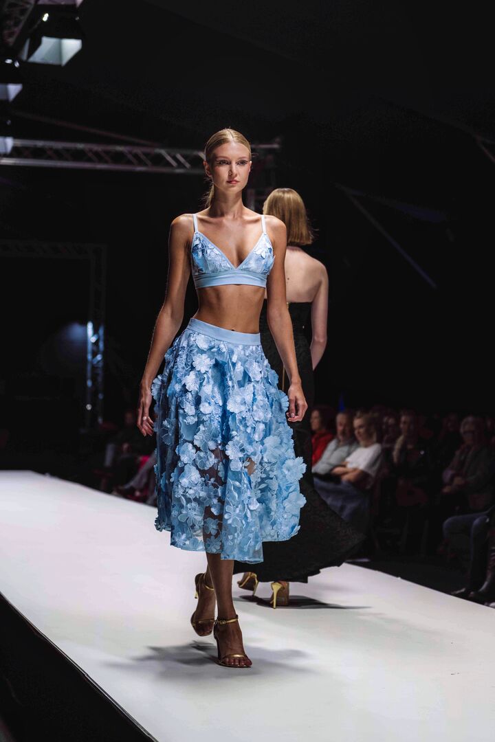 Model trägt einen eisblauen Zweiteiler aus Top und Rock