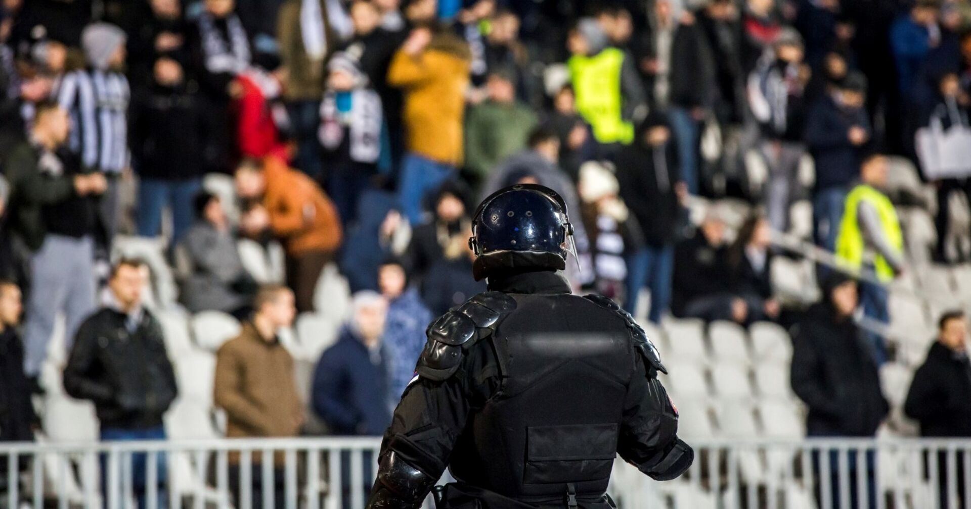 Polizist in voller Montur auf Fußballplatz