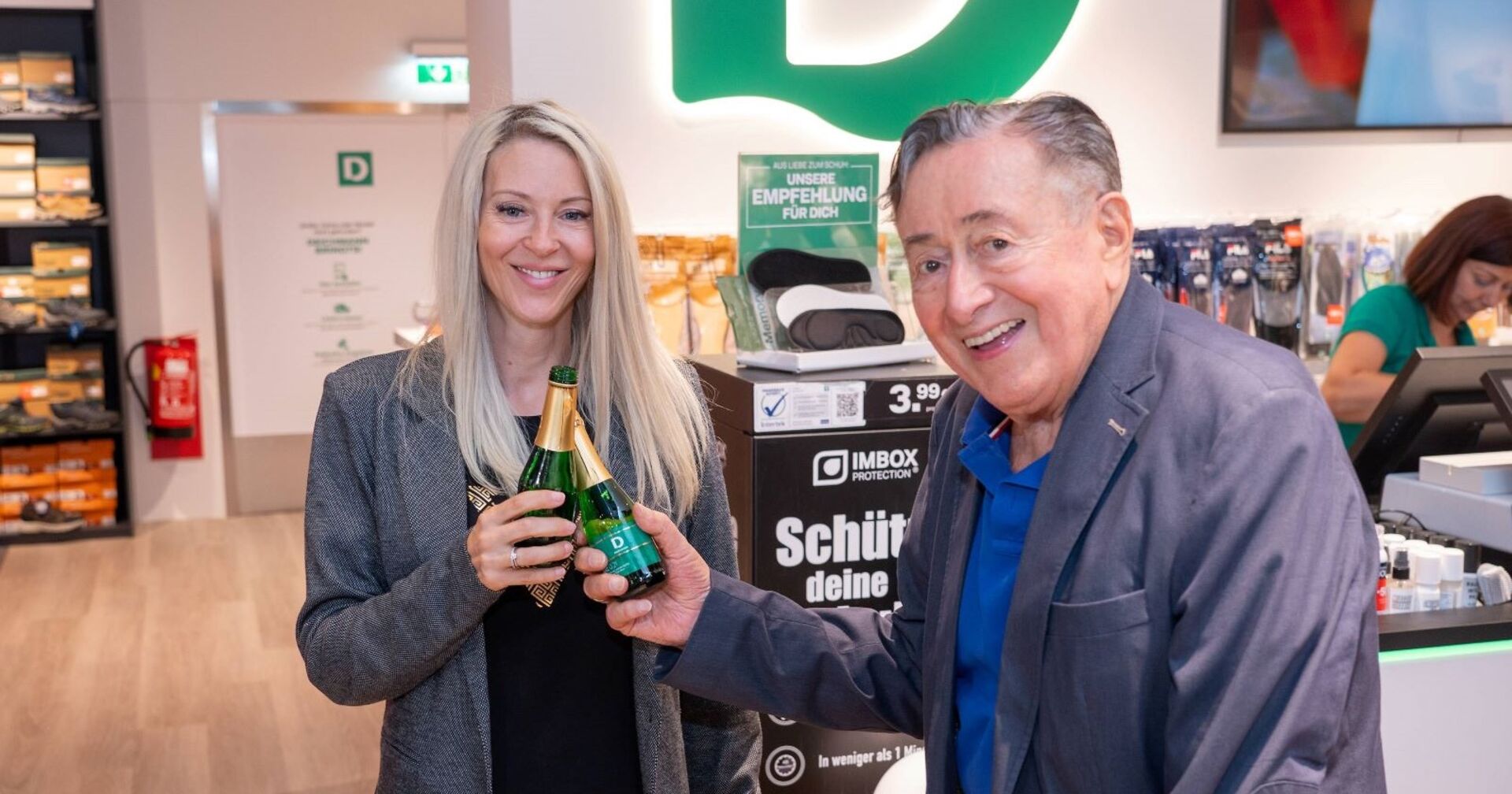 Simone und Richard Lugner stoßen mit Sektflaschen an.