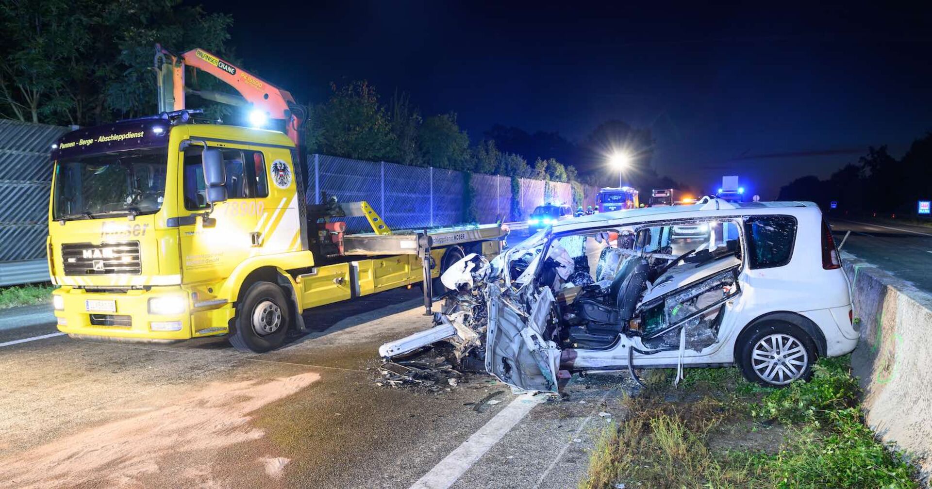Das zerstörte Auto und Rettungskräfte vor Ort.