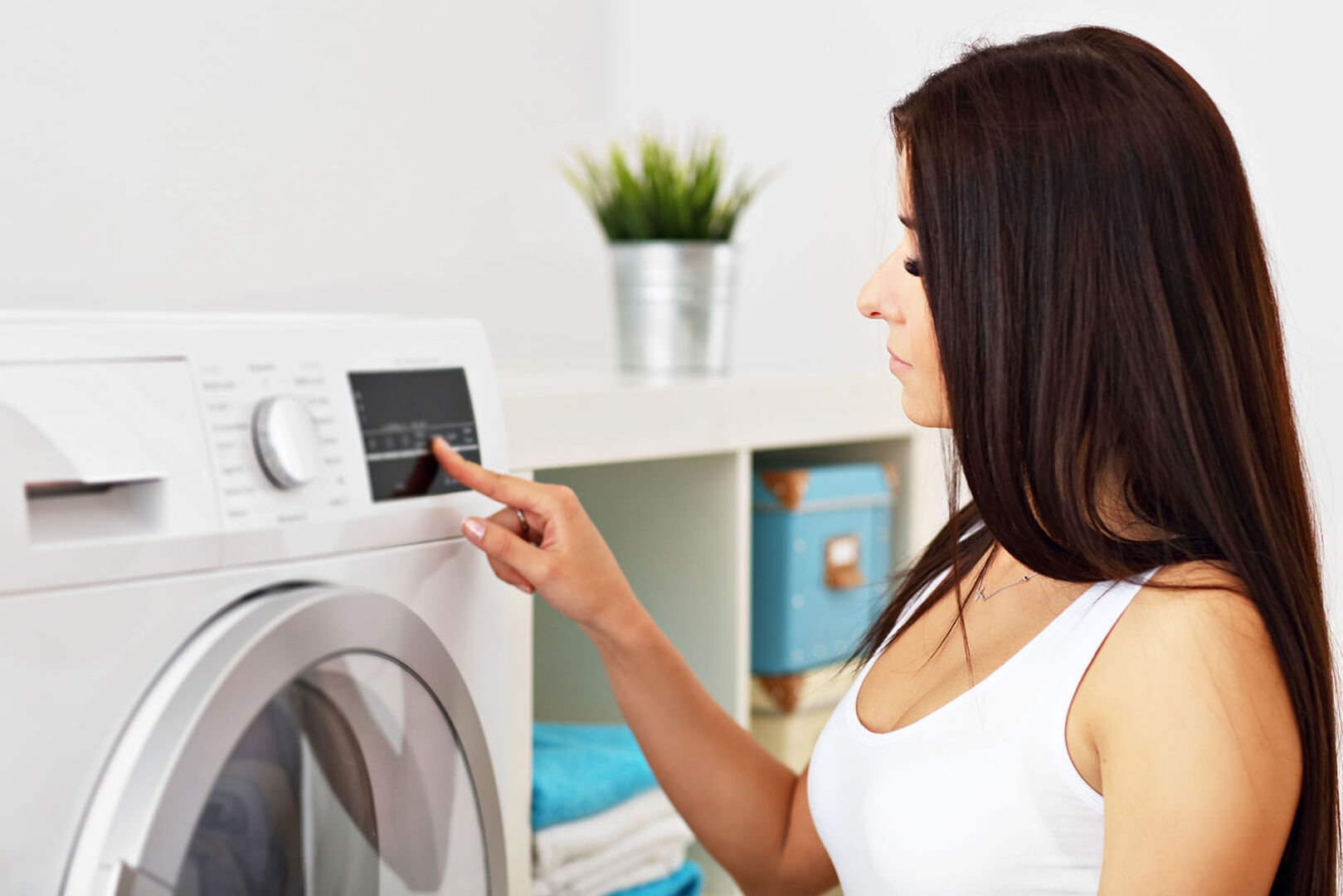 Frau bedient die Waschmaschine | Credit: iStock.com/macniak