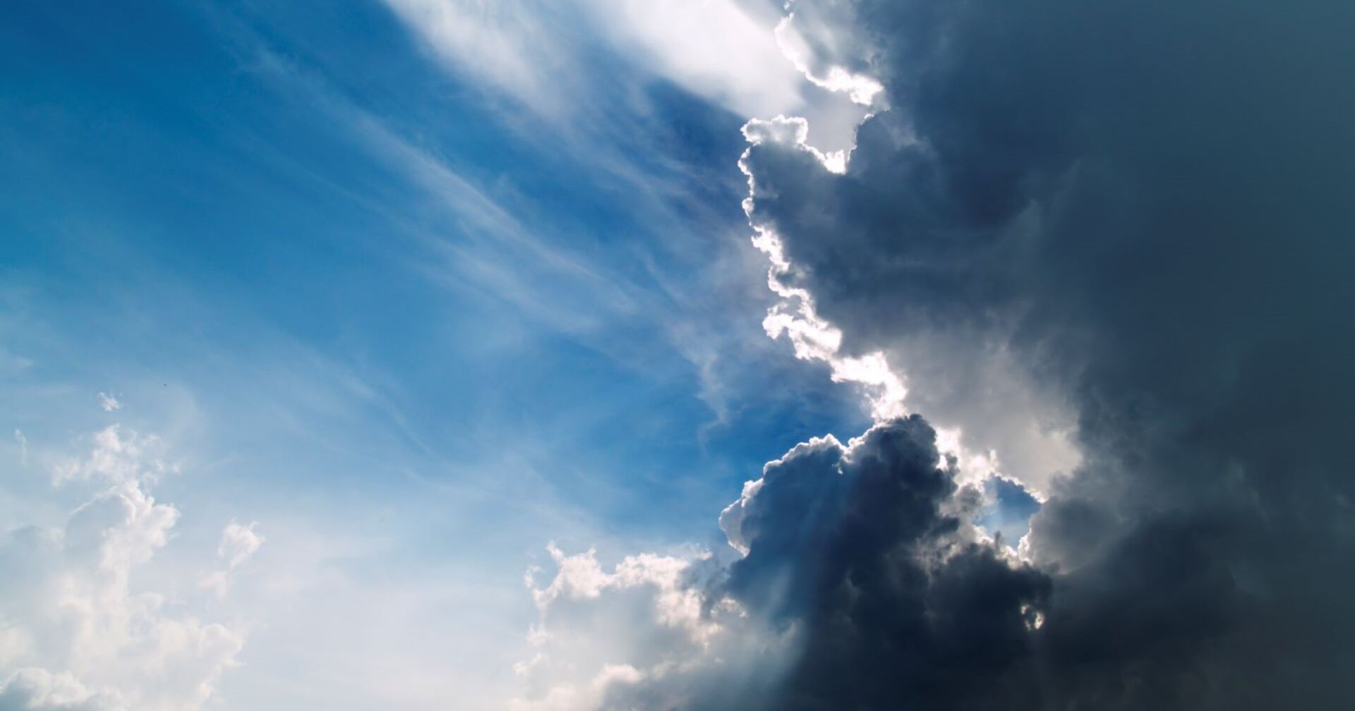 Schwarze Wolken verziehen sich, die Sonne und blauer Himmel kommen durch.