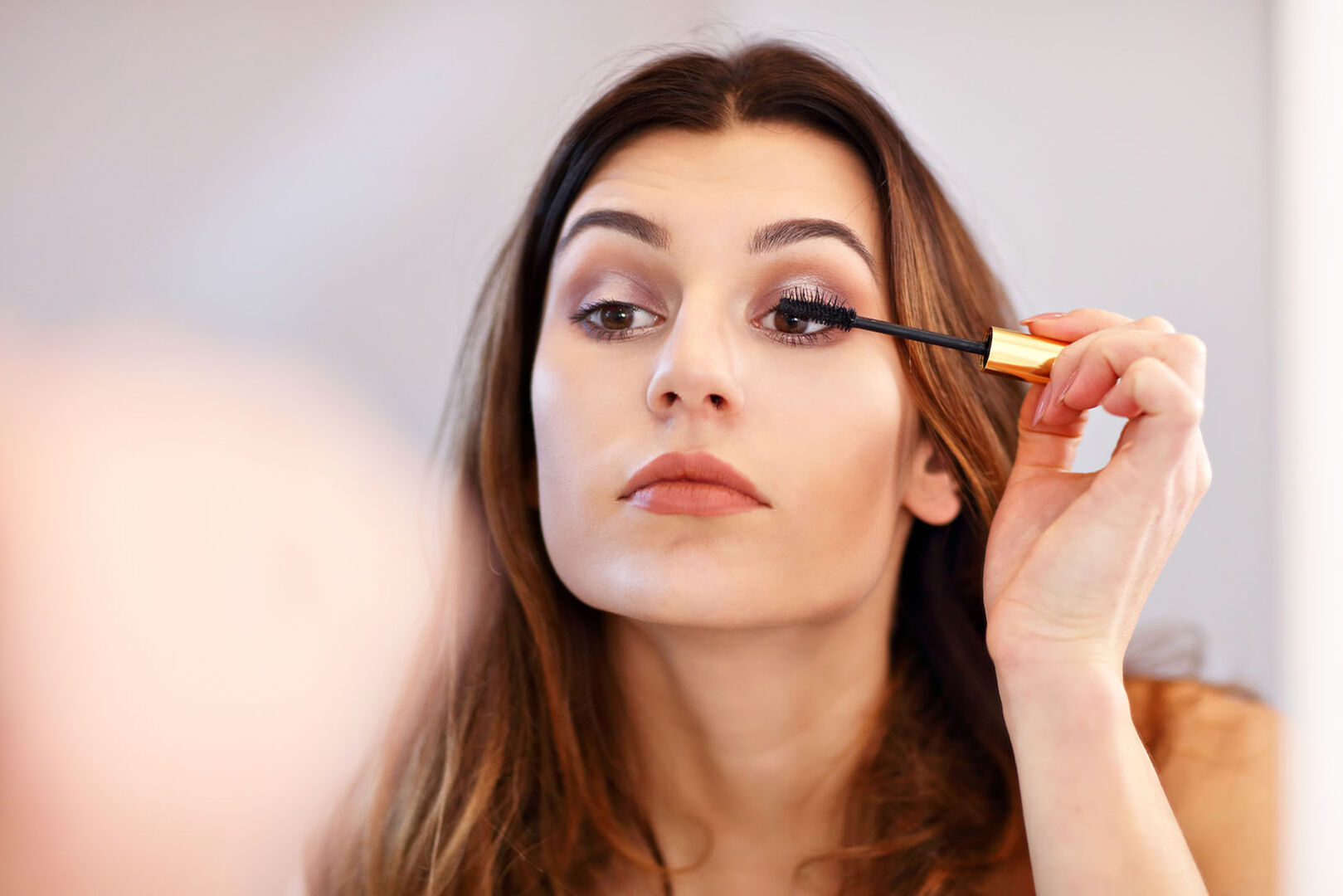 Frau tuscht sich die Wimpern | Credit: iStock.com/macniak