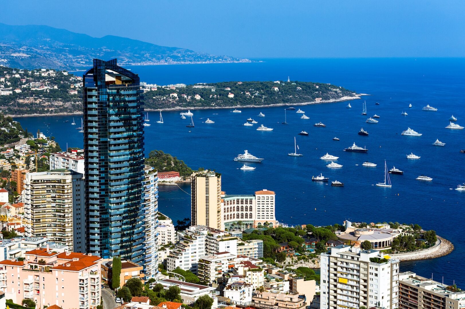 Hochhaus in Monaco, davor Meer und Häuser