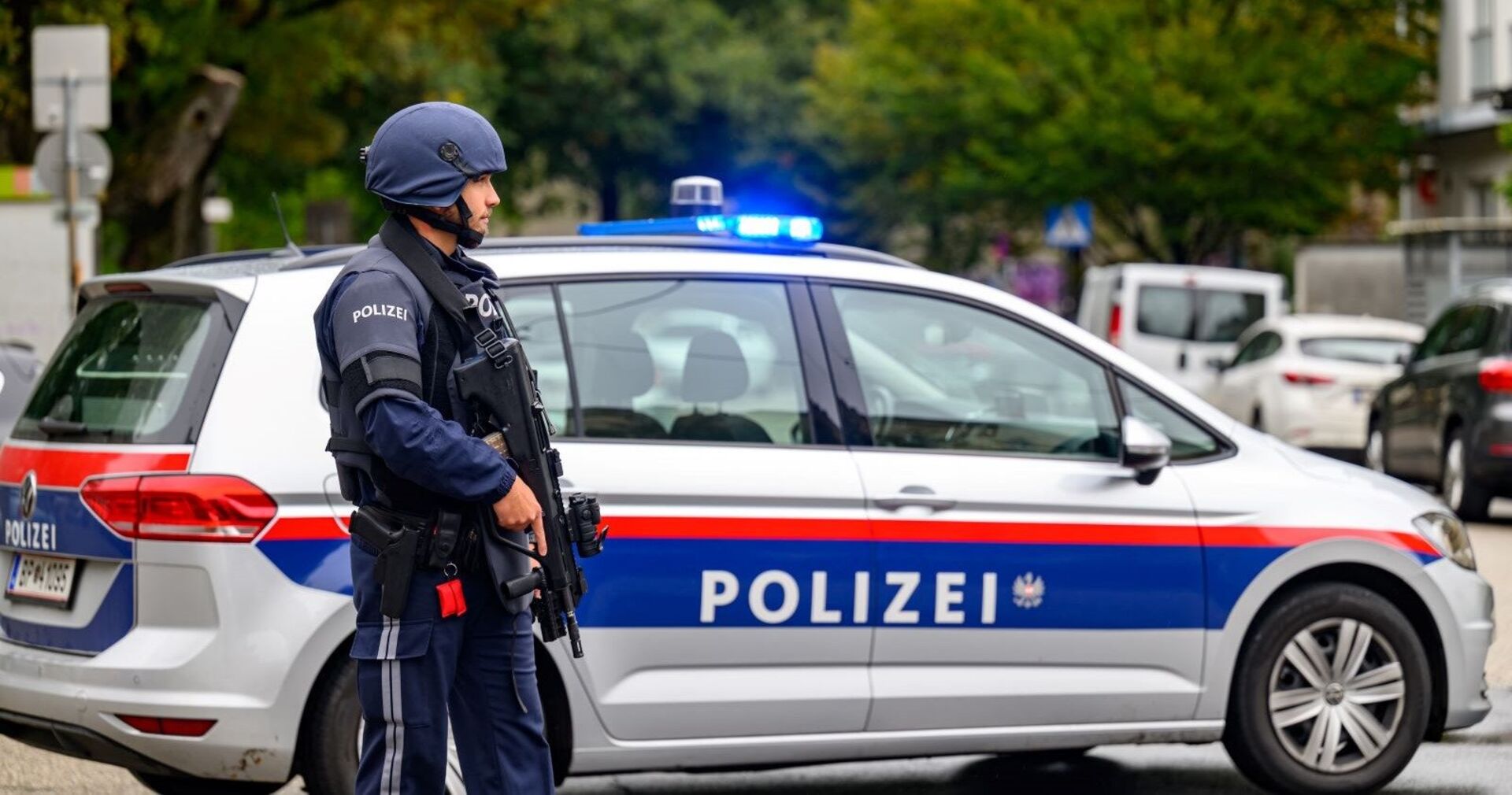 Polizist einer Spezialeinheit vor einem Einsatzwagen.