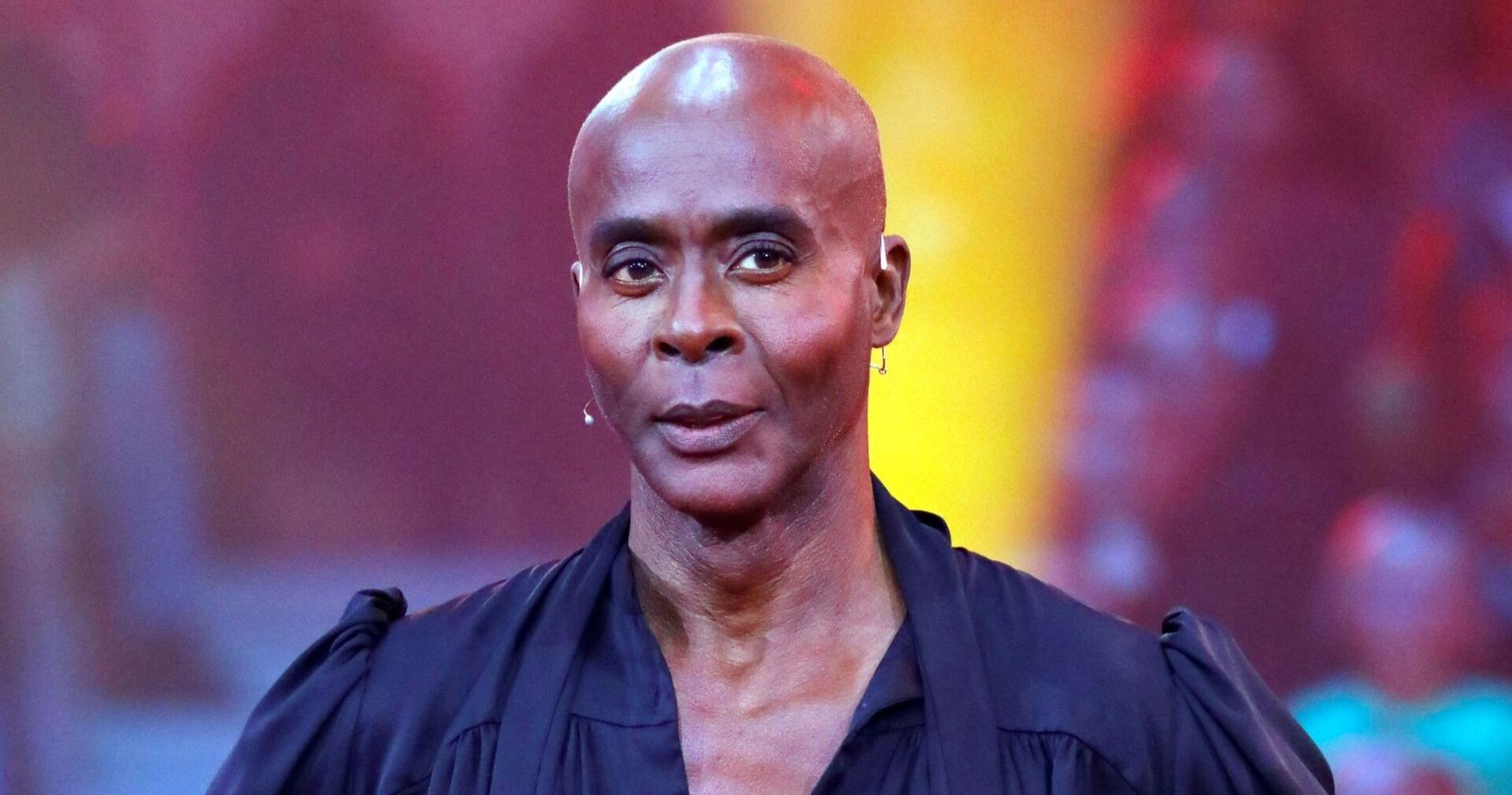 Bruce Darnell in einer schwarzen Bluse