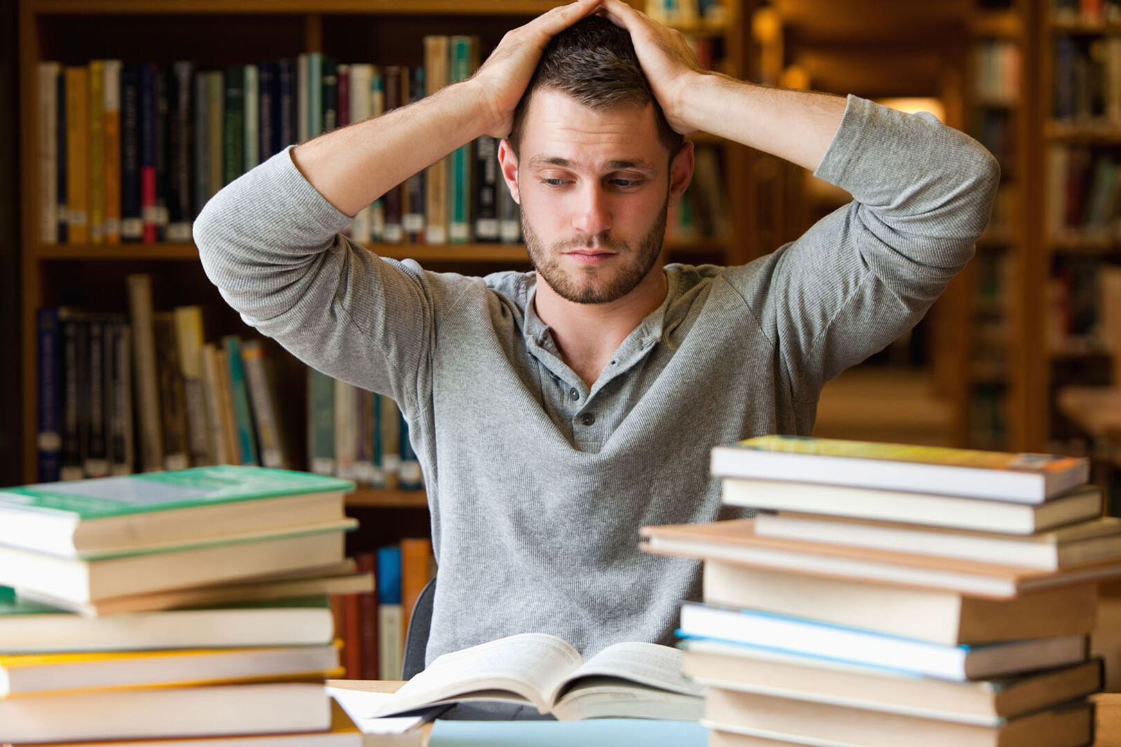 Student sitzt mitten in Büchern | Credit: iStock.com/Wavebreakmedia