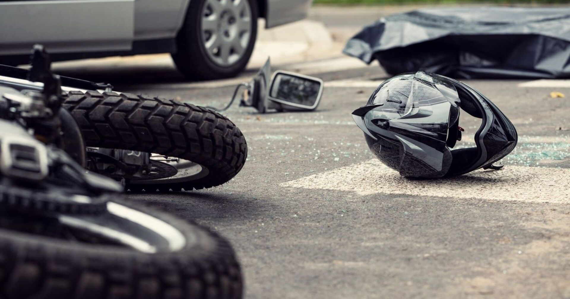 Helm und Motorrad liegen nach einem Unfall auf der Straße.