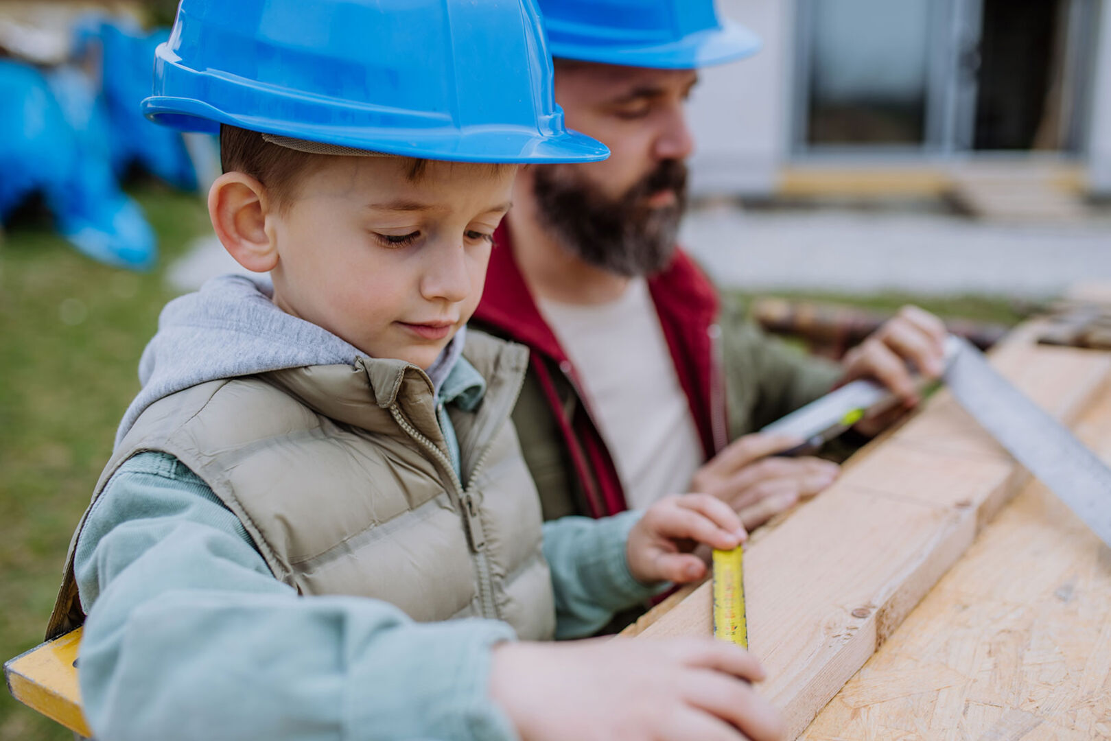 Vater und sein kleiner Sohn beim Vermessen und Zuschneiden | Credit: iStock.com/Halfpoint
