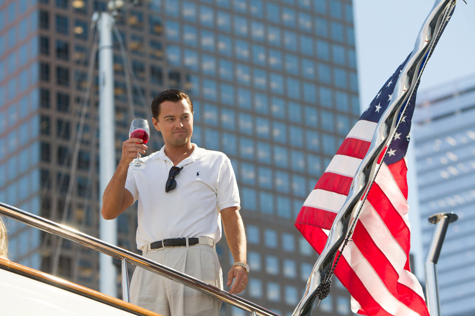 Szenenfoto aus "The Wolf of Wall Street", das Leonardo DiCaprio mit einem Glas Wein in der Hand an Deck einer Luxusyacht zeigt