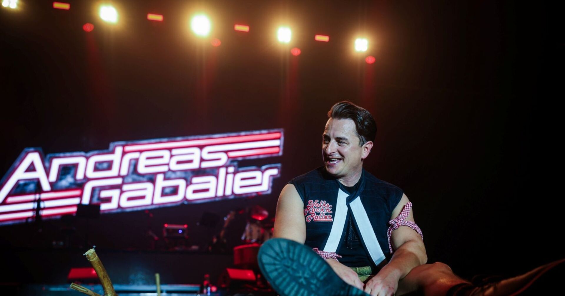 Andreas Gabalier sitzt auf der Bühne