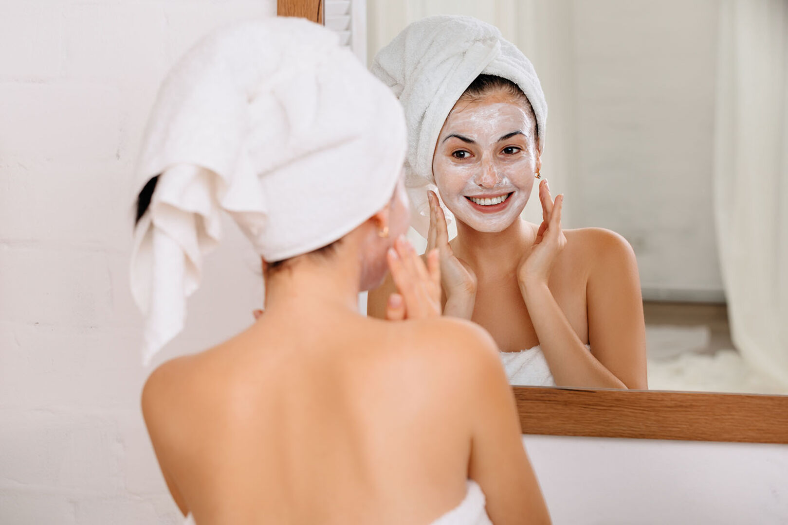 Frau trägt Gesichtsmaske auf | Credit: iStock.com/Erstudiostok