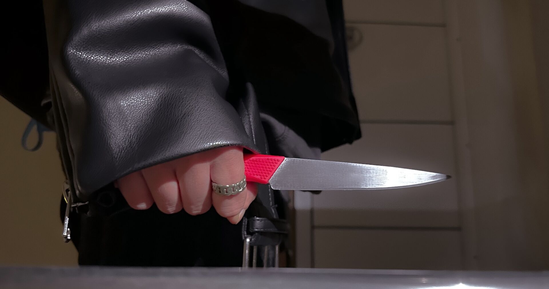 Eine Frau in einer Lederjacke mit einem Messer.