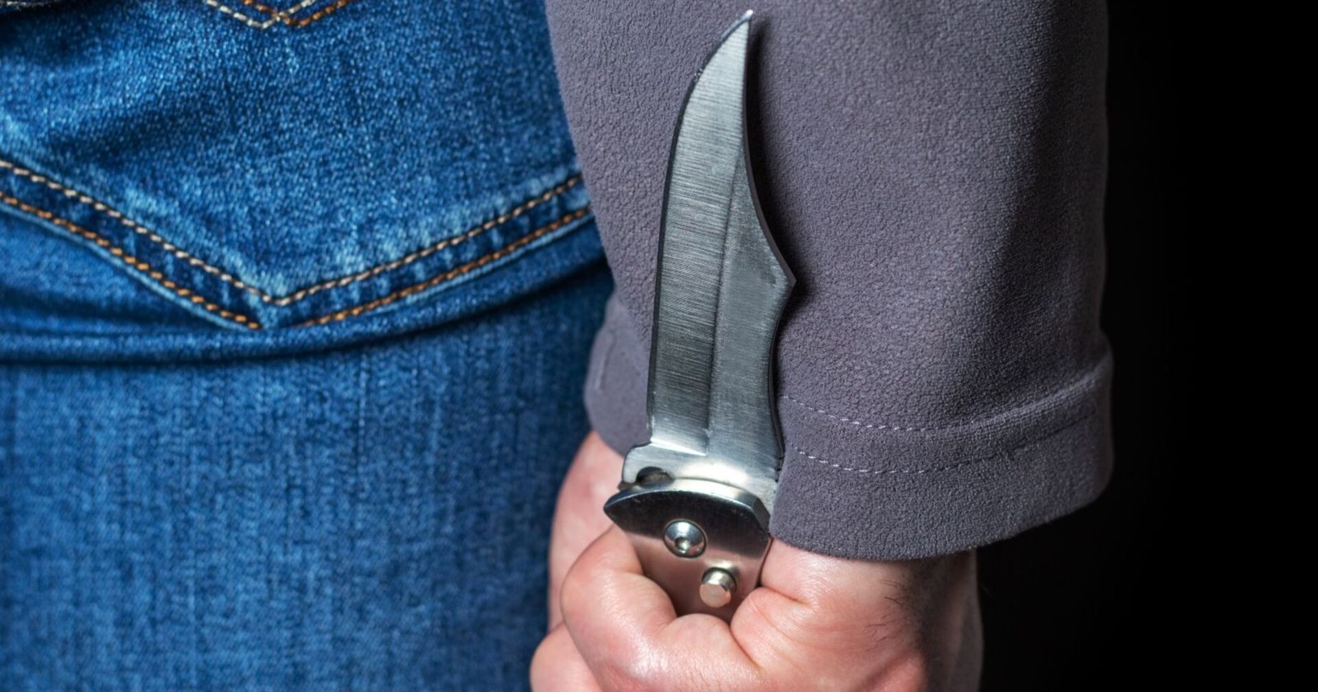 Mann mit Messer hinter dem Rücken versteckt