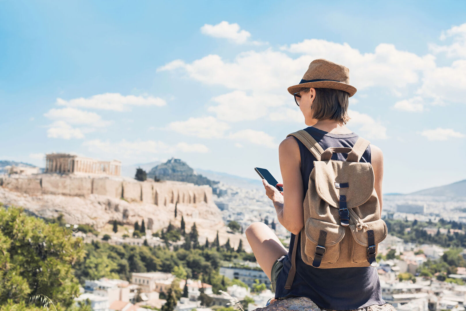 Frau sitzt auf einem Hügel | Credit: iStock.com/Poike