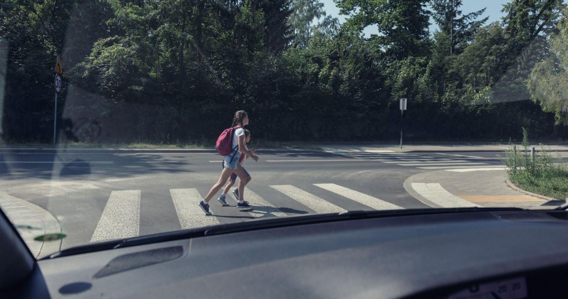 Zwei Kinder überqueren einen Zebrastreifen.
