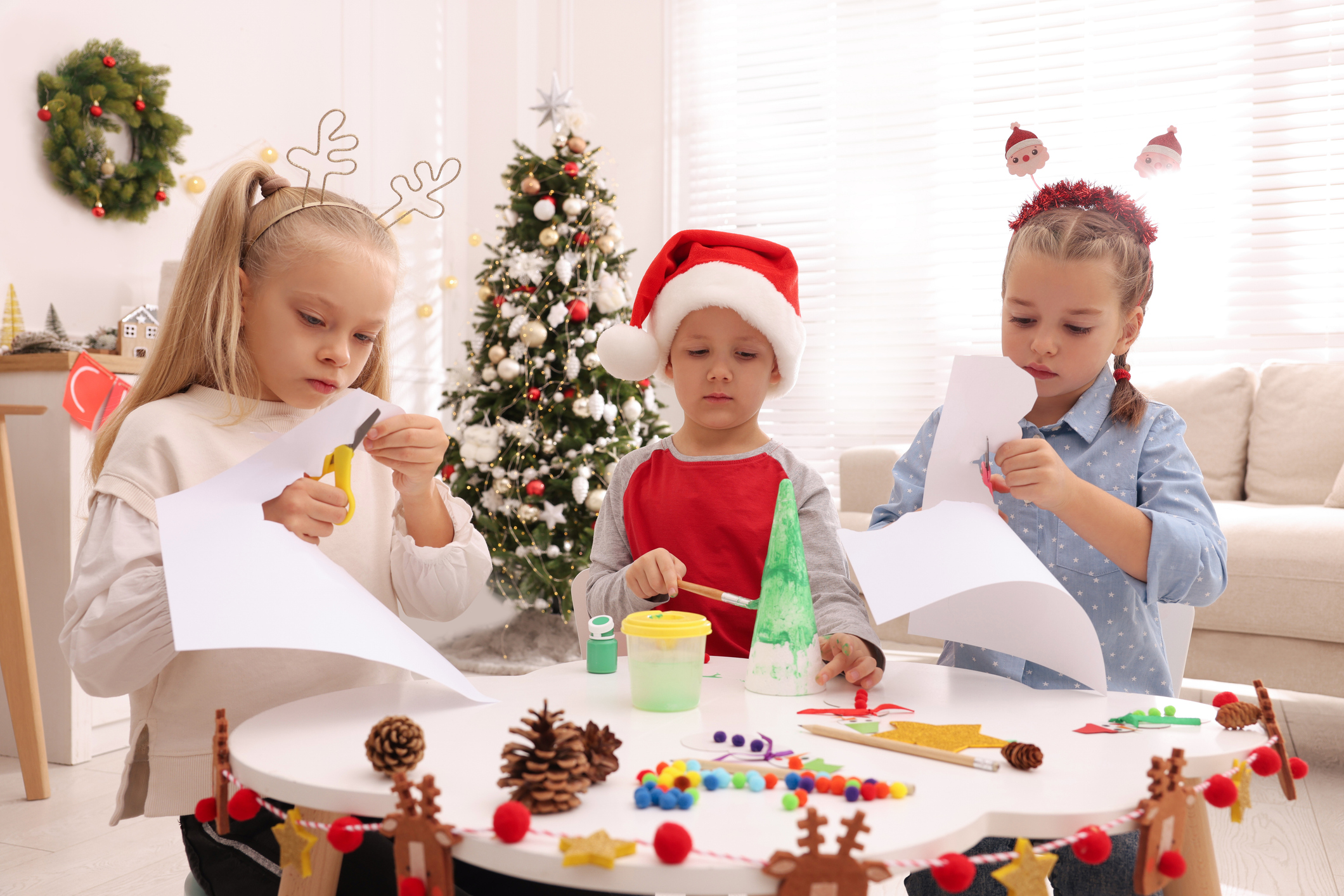 Drei Kinder bastel weihnachtliche Dekoration