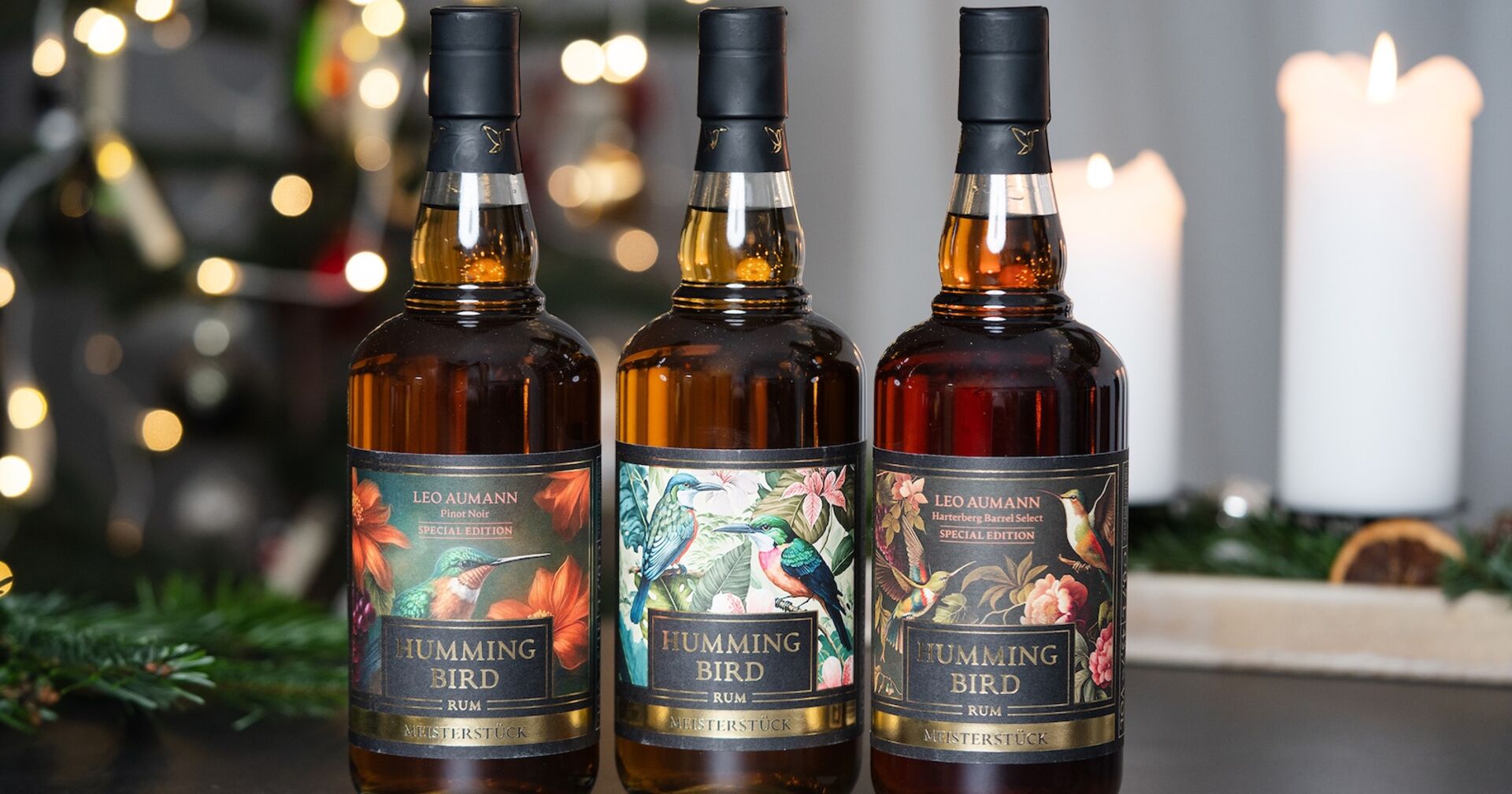 Drei Flaschen Rum mit weihnachtlichem Tannenreisig