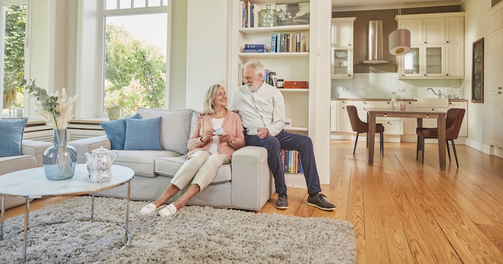 Ein älteres Paar sitzt zuhause am Sofa